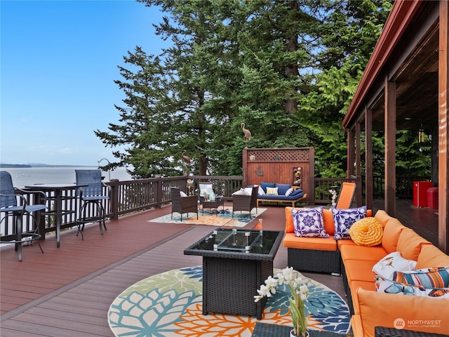 wooden deck with outdoor lounge area and a water view