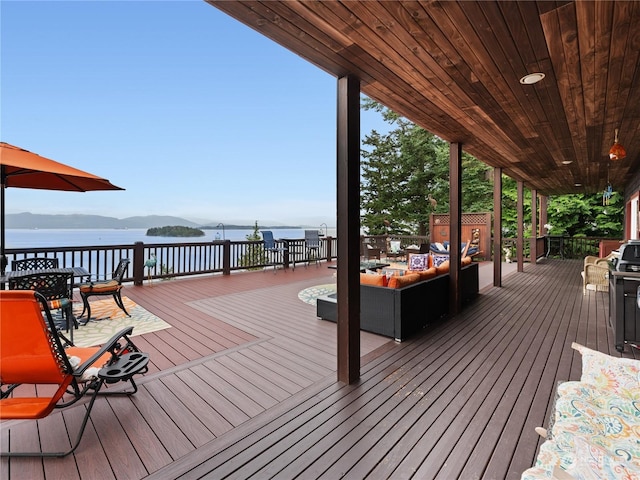 deck with a water view and an outdoor living space