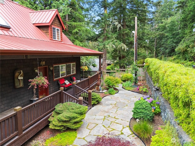 view of yard with covered porch and fence