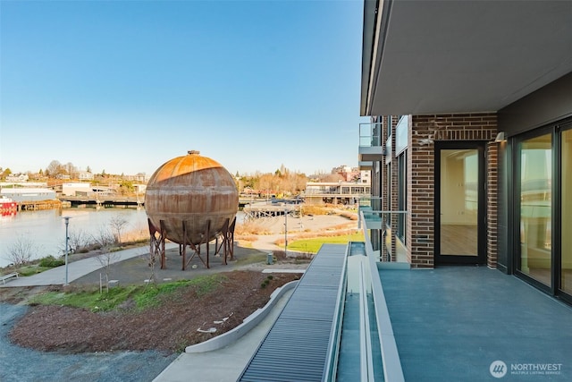 view of patio / terrace with a water view and a balcony