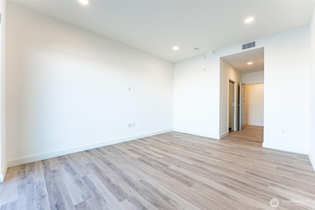 empty room with recessed lighting, light wood-type flooring, and baseboards