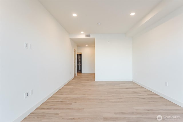 spare room featuring light wood-style floors, visible vents, baseboards, and recessed lighting