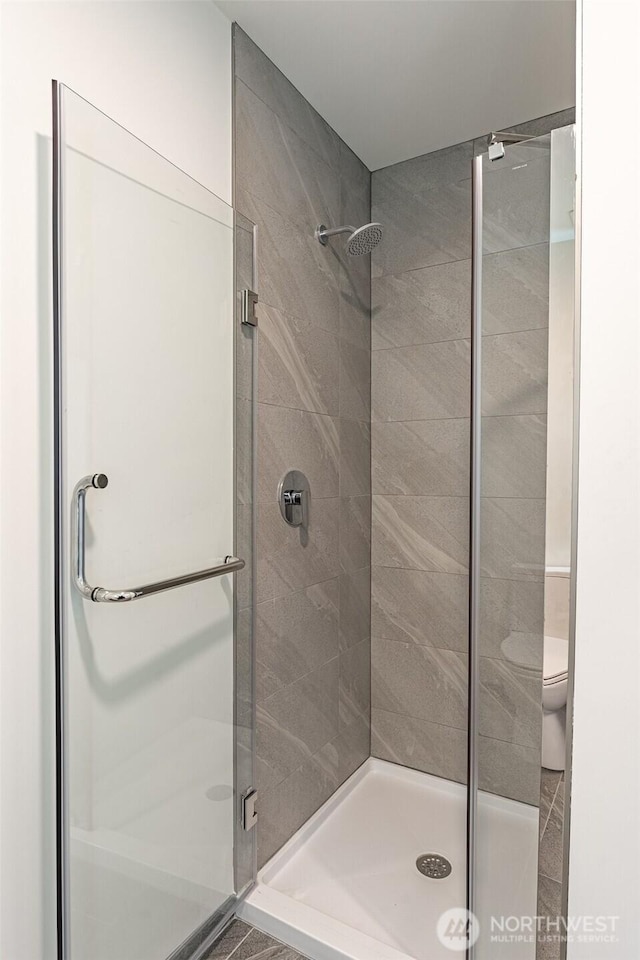 full bathroom with a stall shower and toilet