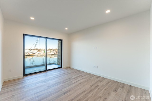 spare room with light wood-style floors, baseboards, and recessed lighting