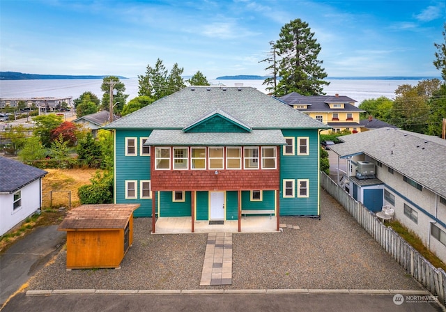 back of property featuring a water view