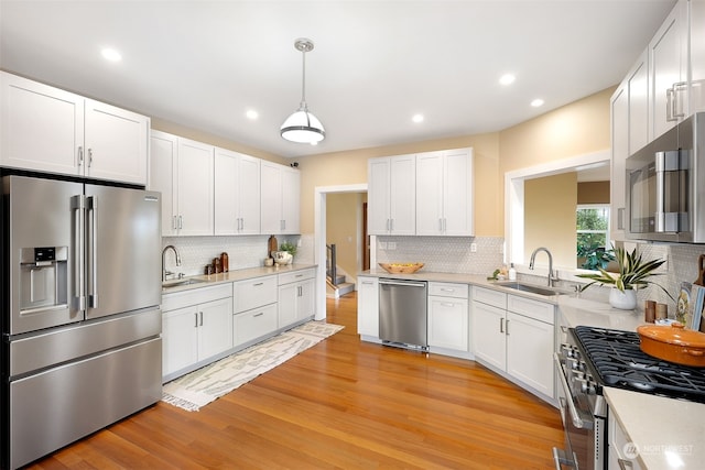 kitchen featuring light wood-type flooring, backsplash, white cabinets, and high quality appliances