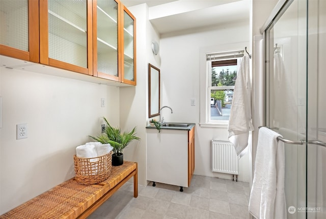 interior space featuring sink, radiator, and light tile patterned flooring