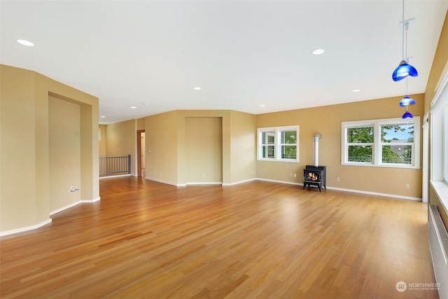 unfurnished living room with light hardwood / wood-style flooring and a wood stove