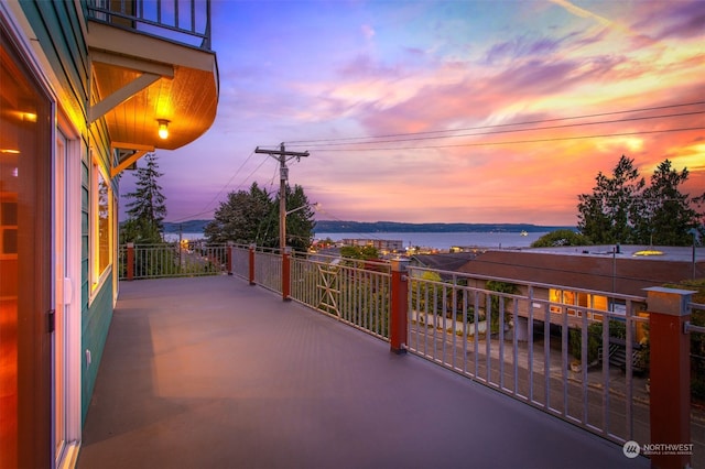 patio terrace at dusk with a balcony and a water view