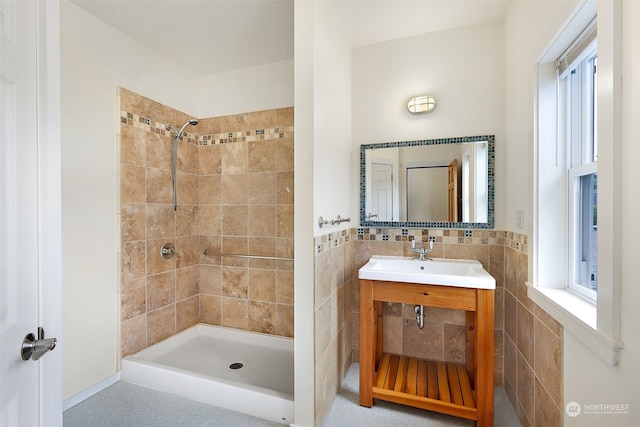 bathroom with tile walls, vanity, and tiled shower