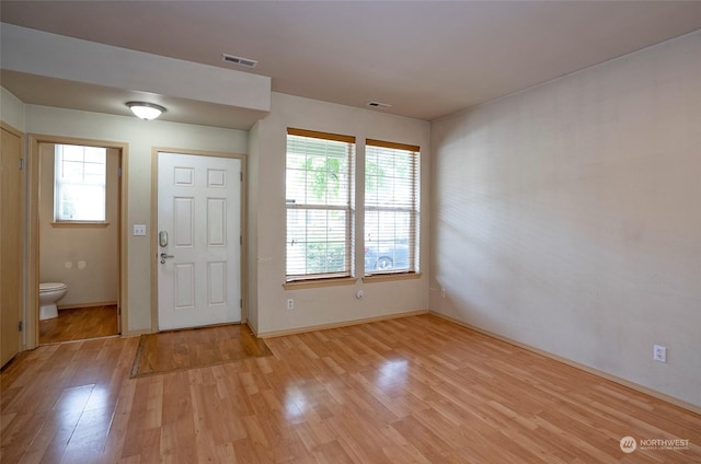 entryway with light wood-style floors, visible vents, and a wealth of natural light