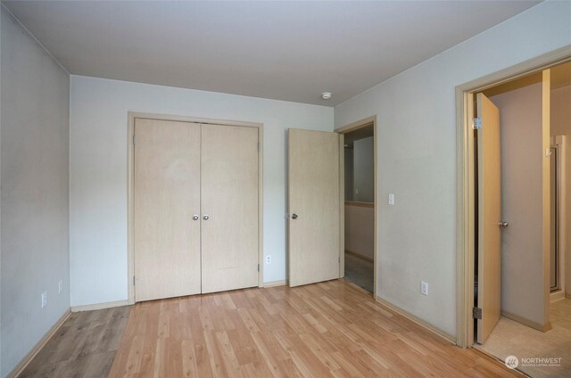 unfurnished bedroom with light wood finished floors, a closet, and baseboards