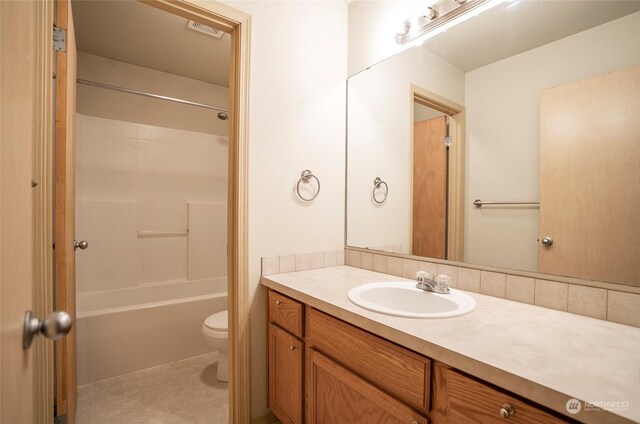 bathroom featuring toilet, shower / bathtub combination, tile patterned flooring, and vanity