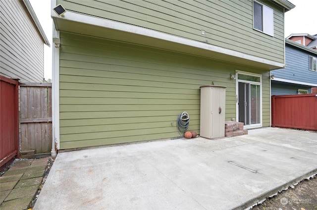 back of property featuring fence and a patio