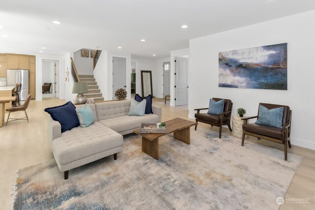 living area with light wood finished floors, stairway, and recessed lighting