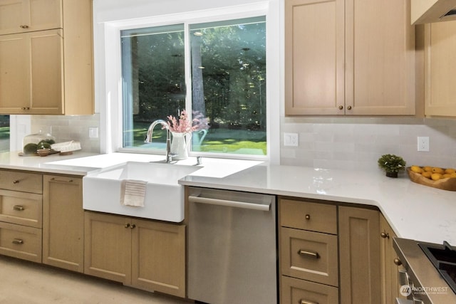 kitchen with dishwasher, light countertops, a sink, and decorative backsplash