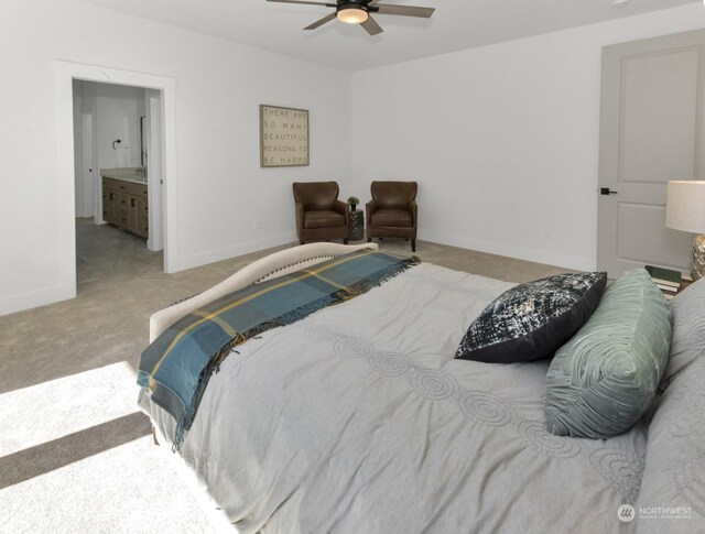 carpeted bedroom featuring ensuite bath, a ceiling fan, and baseboards