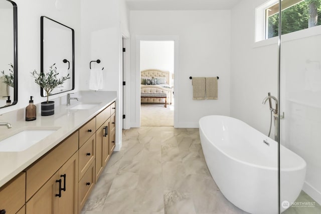 full bath with ensuite bathroom, marble finish floor, a soaking tub, and a sink