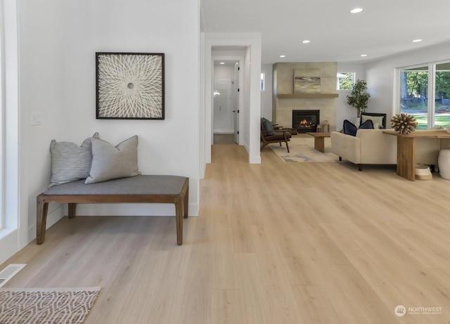 living room with visible vents, a fireplace, light wood-style flooring, and recessed lighting