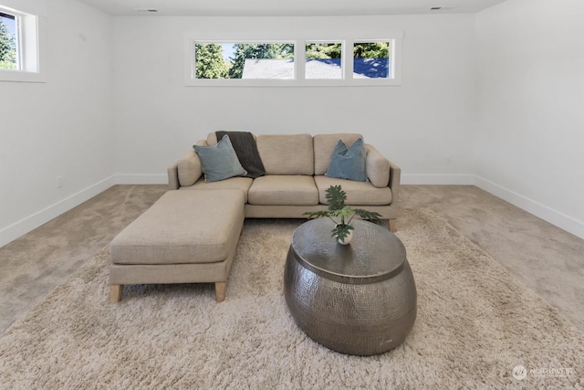 carpeted living area featuring baseboards