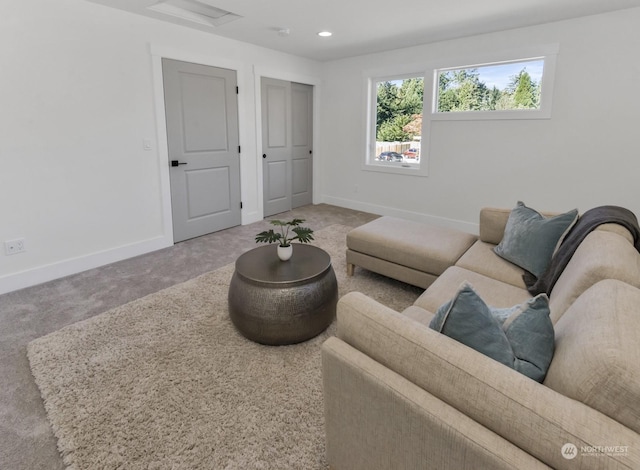 carpeted living room with attic access, baseboards, and recessed lighting