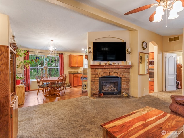 living room featuring ceiling fan with notable chandelier and light carpet