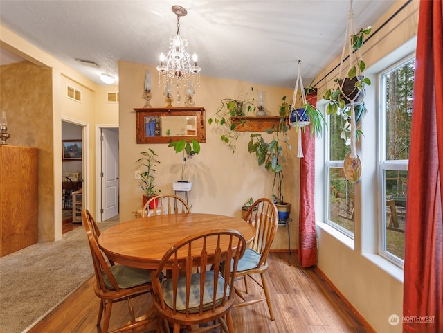 dining space with a notable chandelier and hardwood / wood-style floors