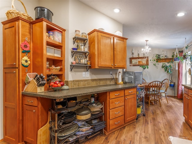 kitchen featuring light wood-type flooring, hanging light fixtures, and an inviting chandelier