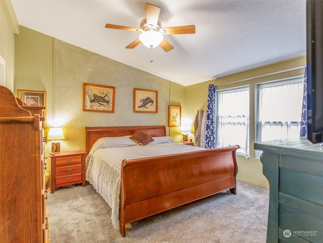 bedroom featuring lofted ceiling, light colored carpet, and ceiling fan