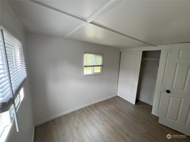 unfurnished bedroom featuring hardwood / wood-style floors and a closet