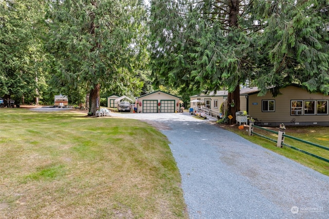 view of front of home with a garage, a front lawn, and an outdoor structure