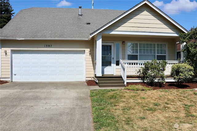 view of front of property with a garage, a front yard, and a porch