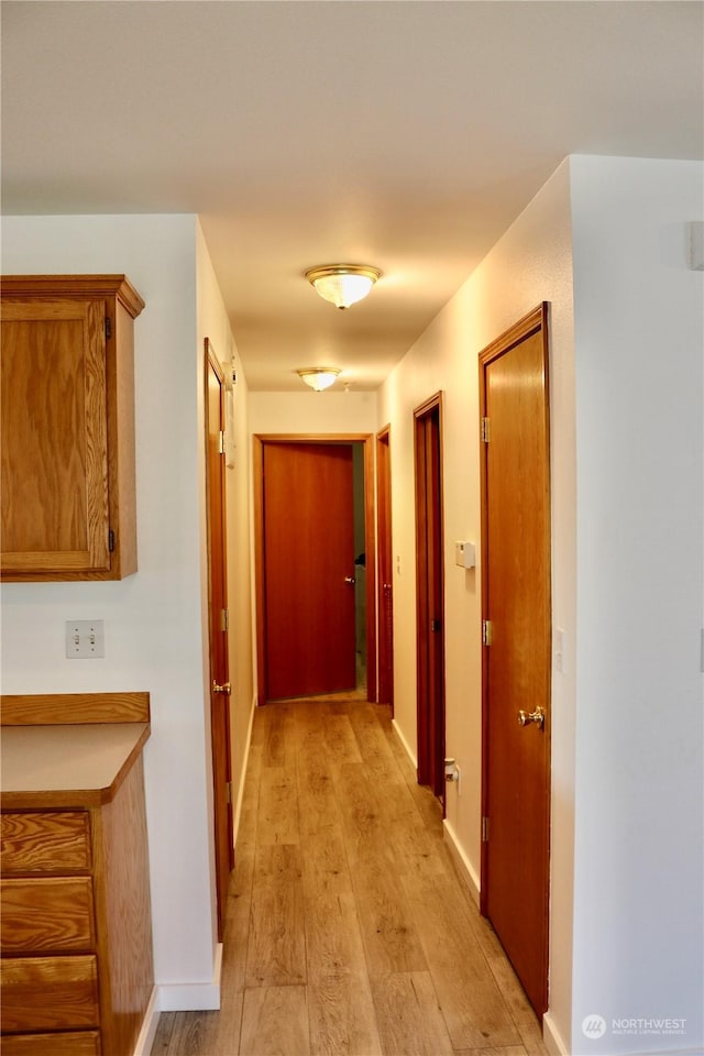 hallway with light hardwood / wood-style flooring