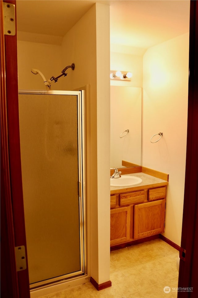 bathroom with vanity and a shower with door