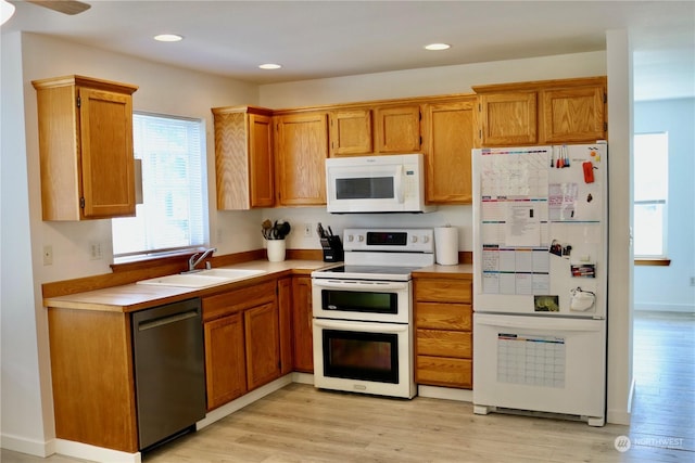 kitchen featuring white appliances, sink, and light hardwood / wood-style flooring