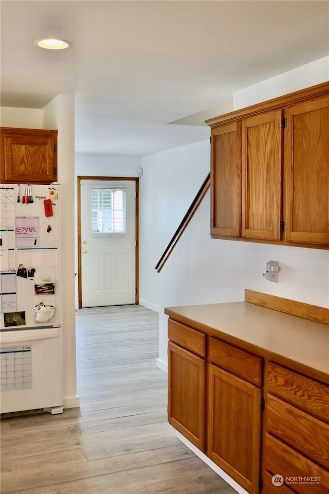 kitchen with light hardwood / wood-style flooring and white refrigerator