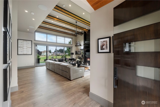 living room featuring a towering ceiling and light hardwood / wood-style flooring