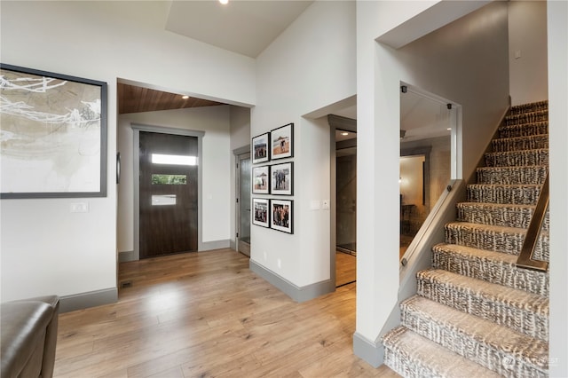 foyer entrance featuring high vaulted ceiling and light wood-type flooring