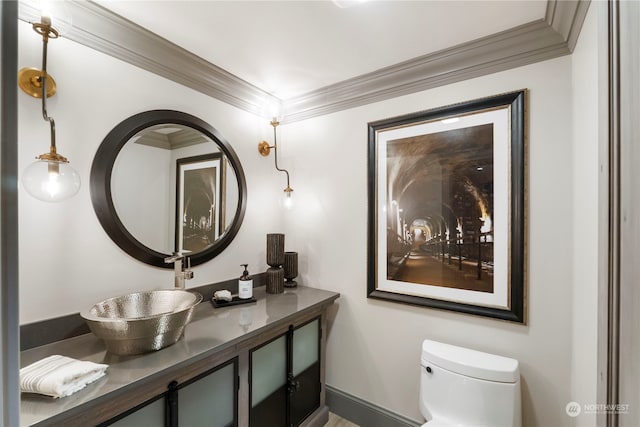 bathroom with vanity, toilet, and crown molding