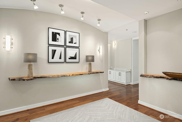 corridor featuring vaulted ceiling and hardwood / wood-style flooring