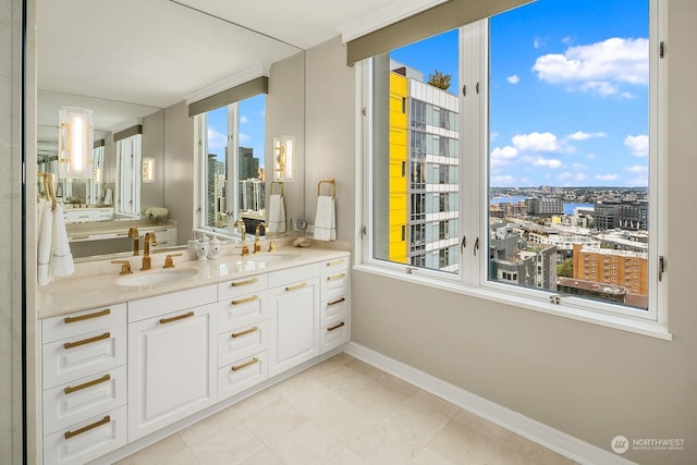 bathroom featuring double vanity, a view of city, and a sink