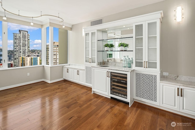 bar with a view of city, wine cooler, dark wood-type flooring, and a sink