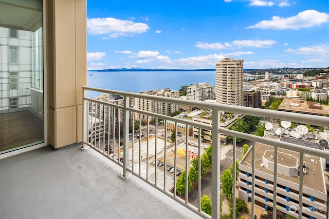 balcony featuring a water view and a city view