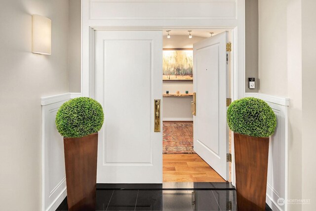 hall with track lighting and wood-type flooring