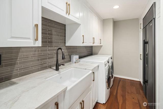 laundry room with dark wood-style floors, cabinet space, a sink, independent washer and dryer, and baseboards