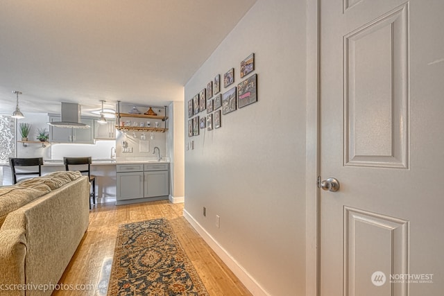 hall with sink and light wood-type flooring