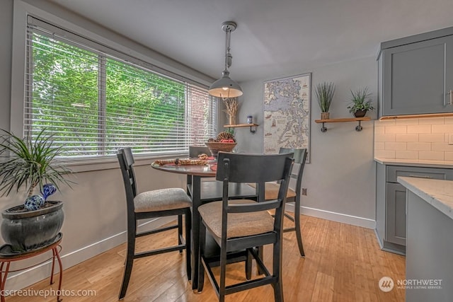 dining area with light wood-style floors and baseboards