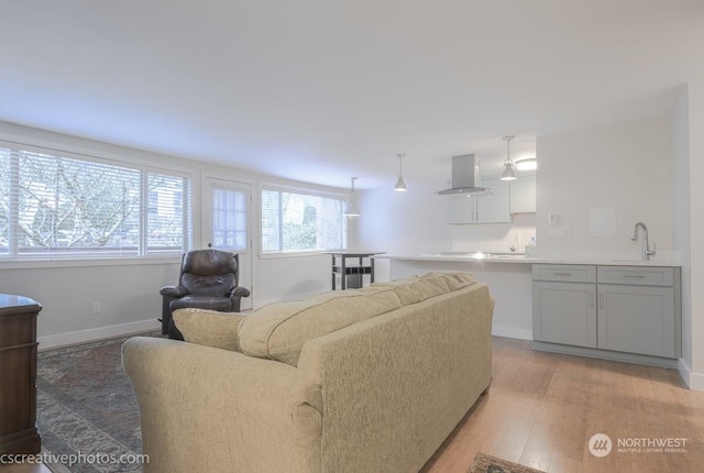 living area featuring a wealth of natural light, baseboards, and light wood-style floors