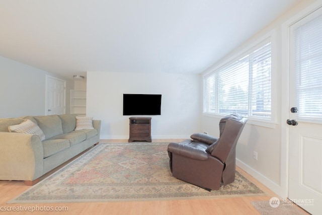 living area featuring baseboards and wood finished floors