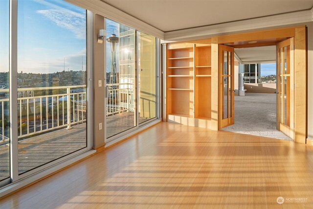 spare room with floor to ceiling windows and light hardwood / wood-style floors